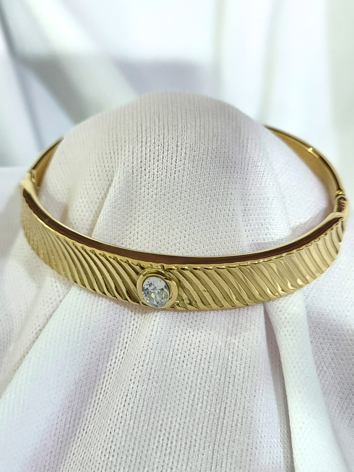 Anti tarnish gold-tone bracelet with textured design and stone close view
