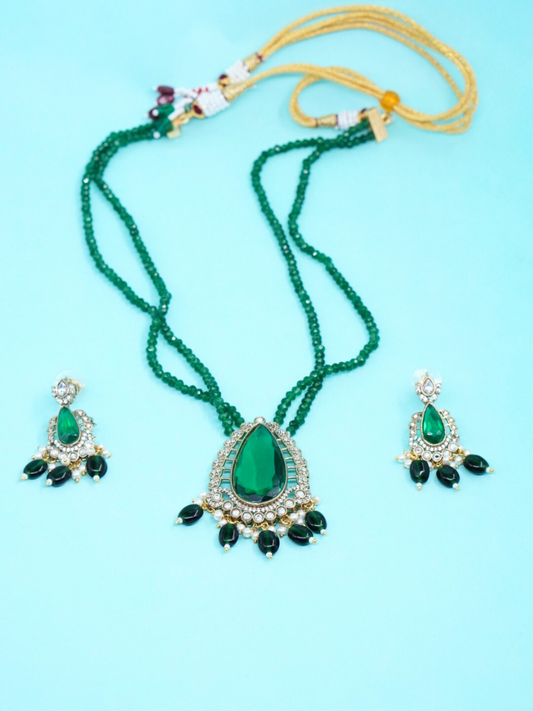 Green onyx long necklace set with matching earrings on blue background