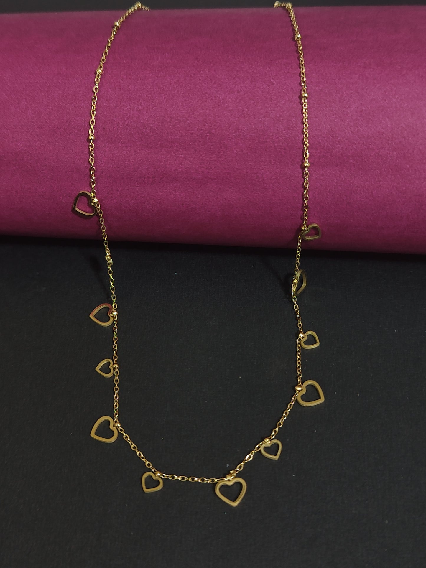Anti-tarnish gold-plated heart charm necklace with heart-shaped pendants.