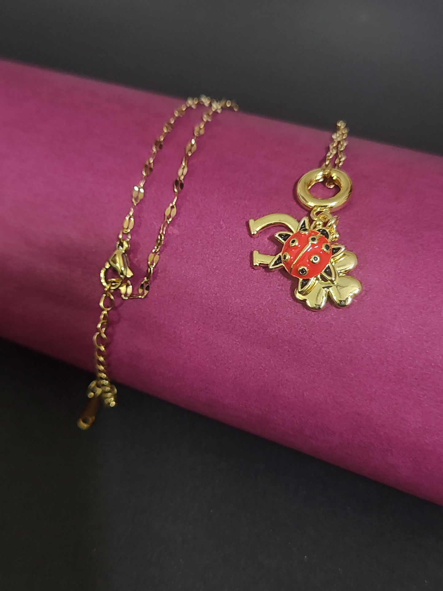 Anti-tarnish ladybug charm necklace with four-leaf clover pendant.