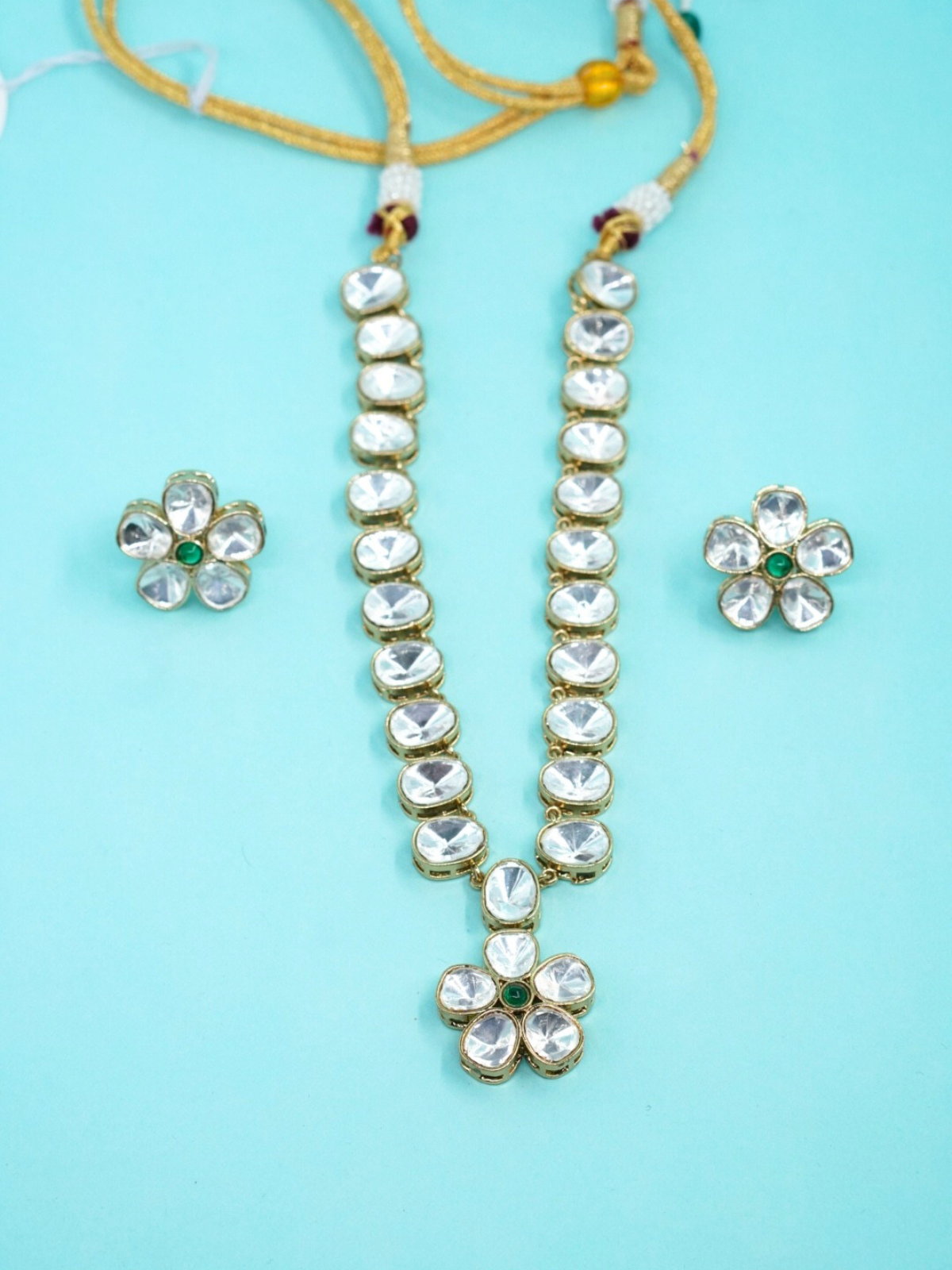 Moissanite floral necklace with matching earrings on blue background