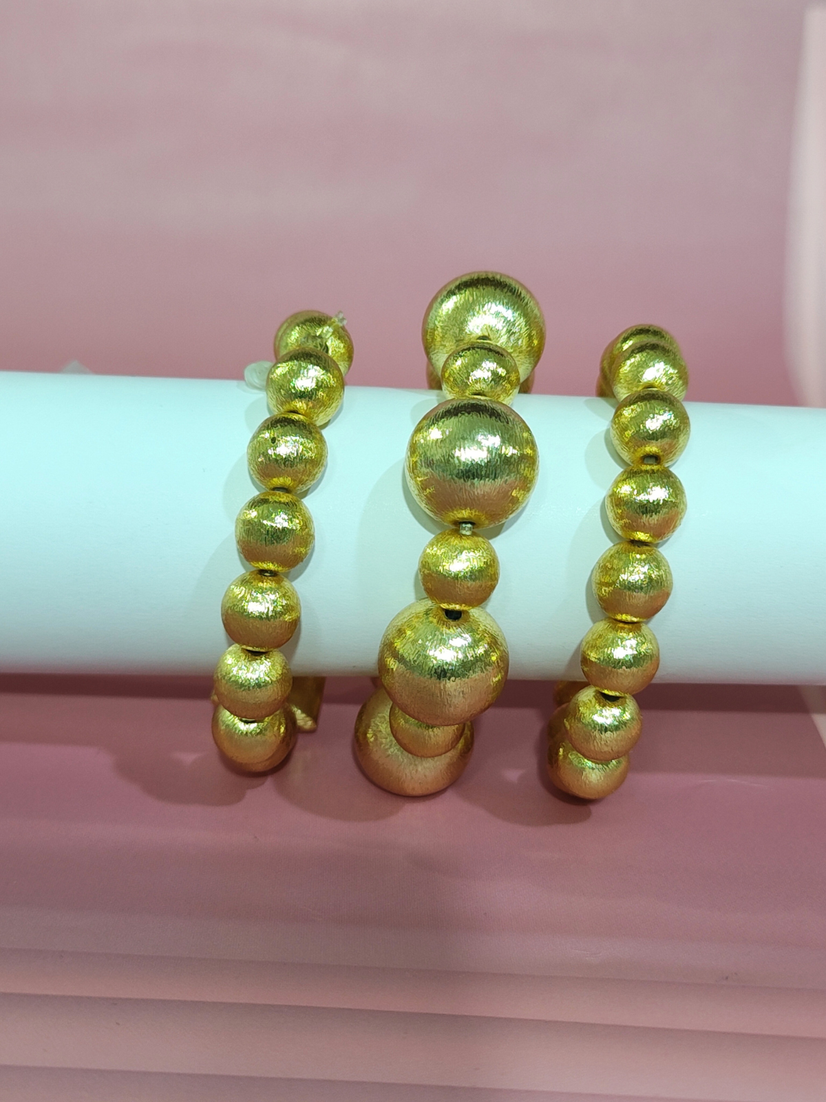 Pure brass gold beaded bracelet with chunky design on pik back ground