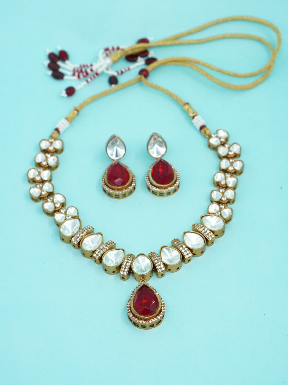 Red stone uncut Moissanite necklace set with matching earrings on blue background close view