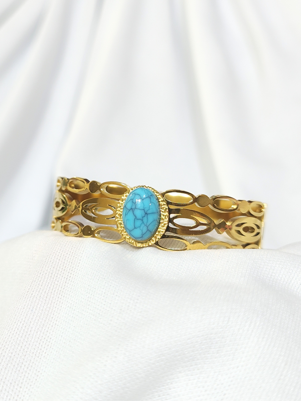Turquoise stone wide gold finish bracelet with open cut design close view