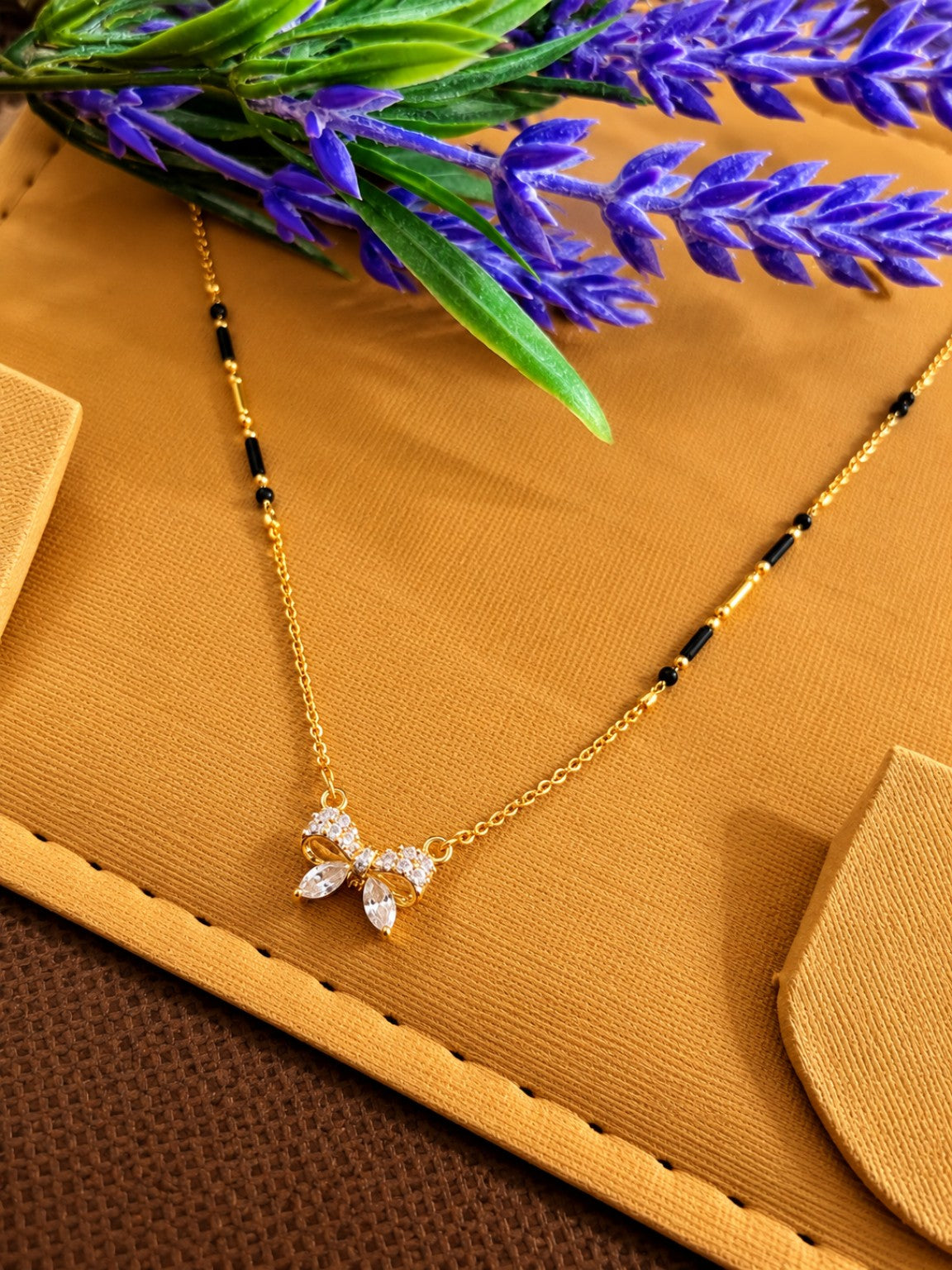 Micro gold-plated black bead mangalsutra with butterfly-style pendant and marquise clear stones