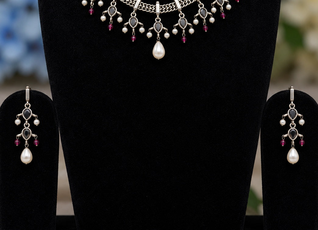 Detail view of oxidised silver replica necklace and matching earrings with pearl drops