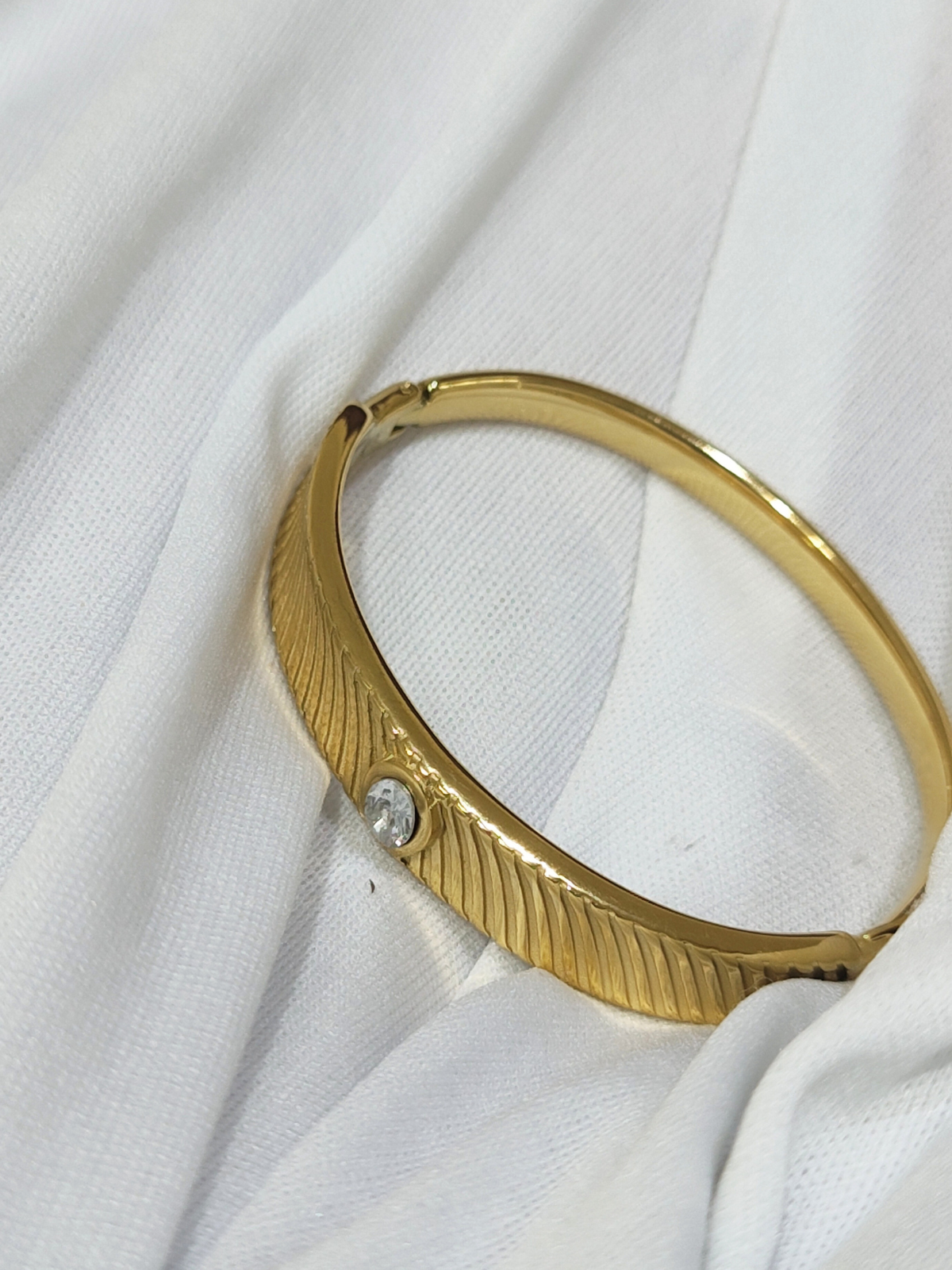 Anti tarnish gold-tone bracelet with textured design and stone