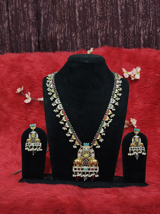 Silver replica temple necklace with cow motif pendant, ruby & green stones, and pearl drops on black display