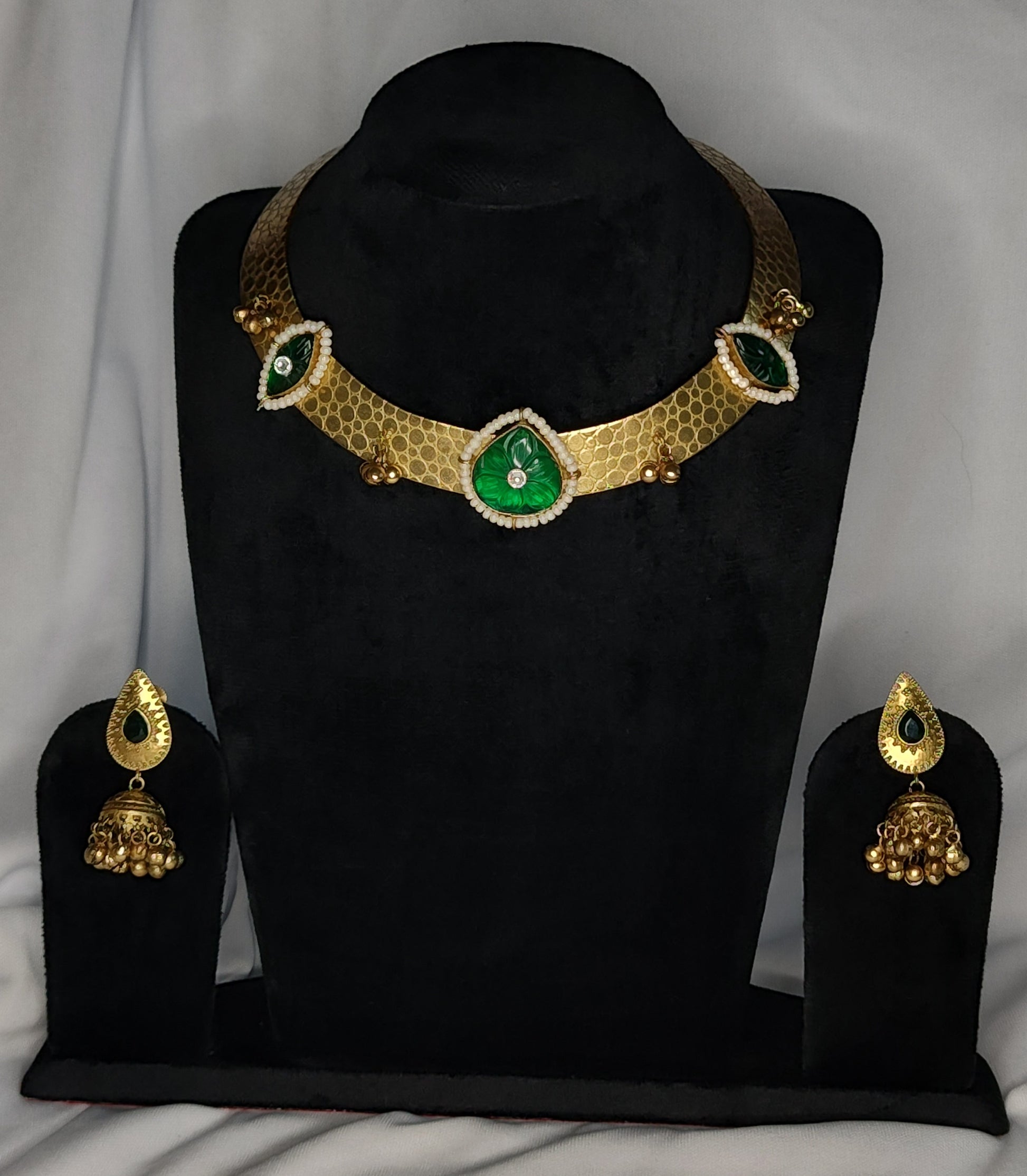 Traditional Hausli necklace set with green stones, pearl detailing, and gold jhumka earrings