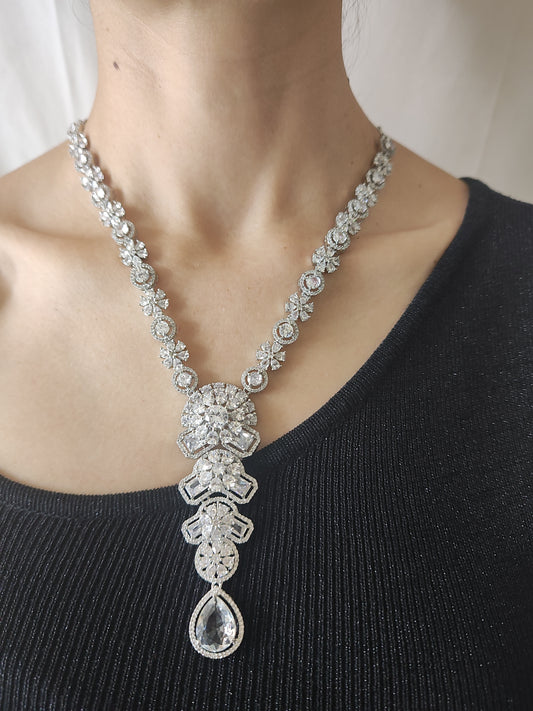 Elegant American Diamond necklace set with floral design, teardrop pendant, and matching earrings – perfect for festive and party wear