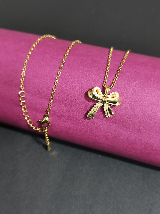 Anti-tarnish bow charm necklace with pearl detailing.