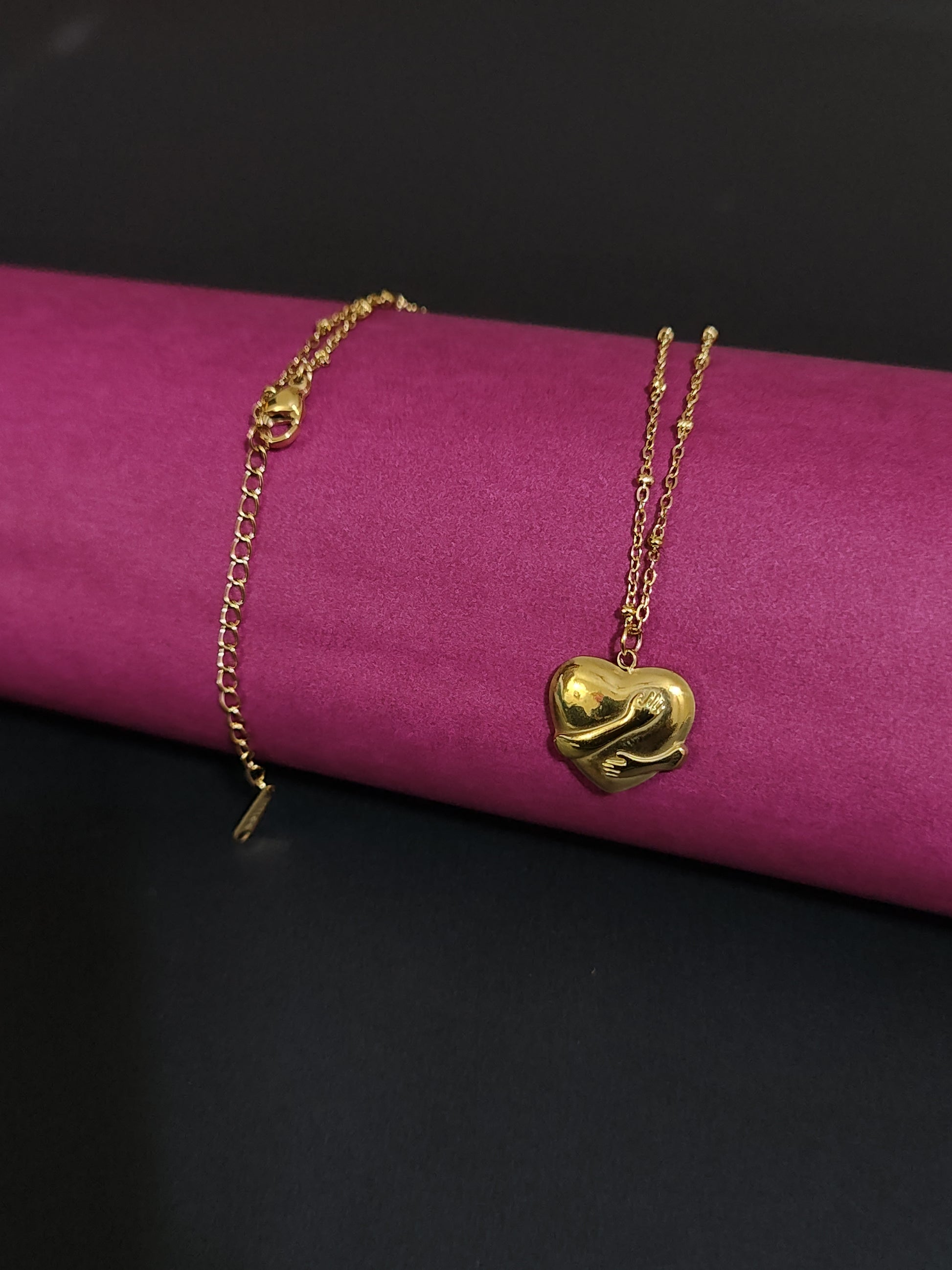 Anti-tarnish heart charm necklace with embracing hands design.