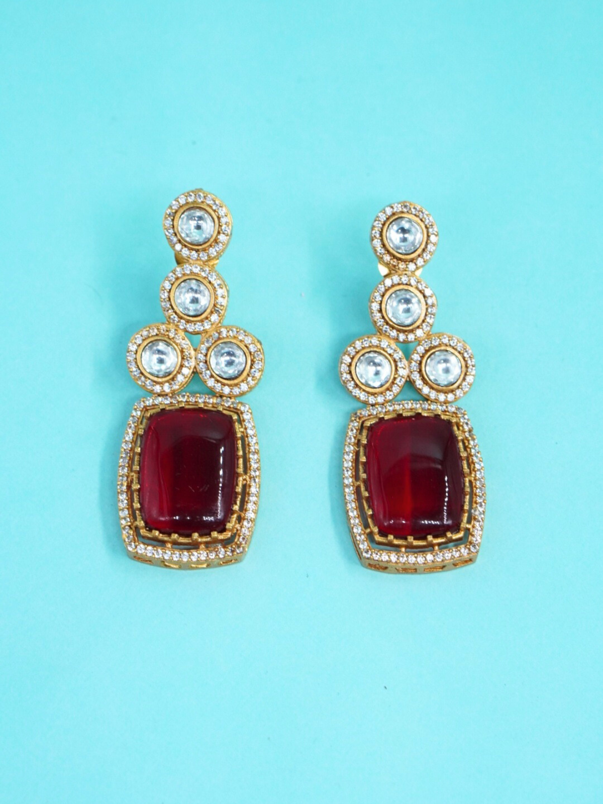 Moissanite ruby red stone earrings on blue background