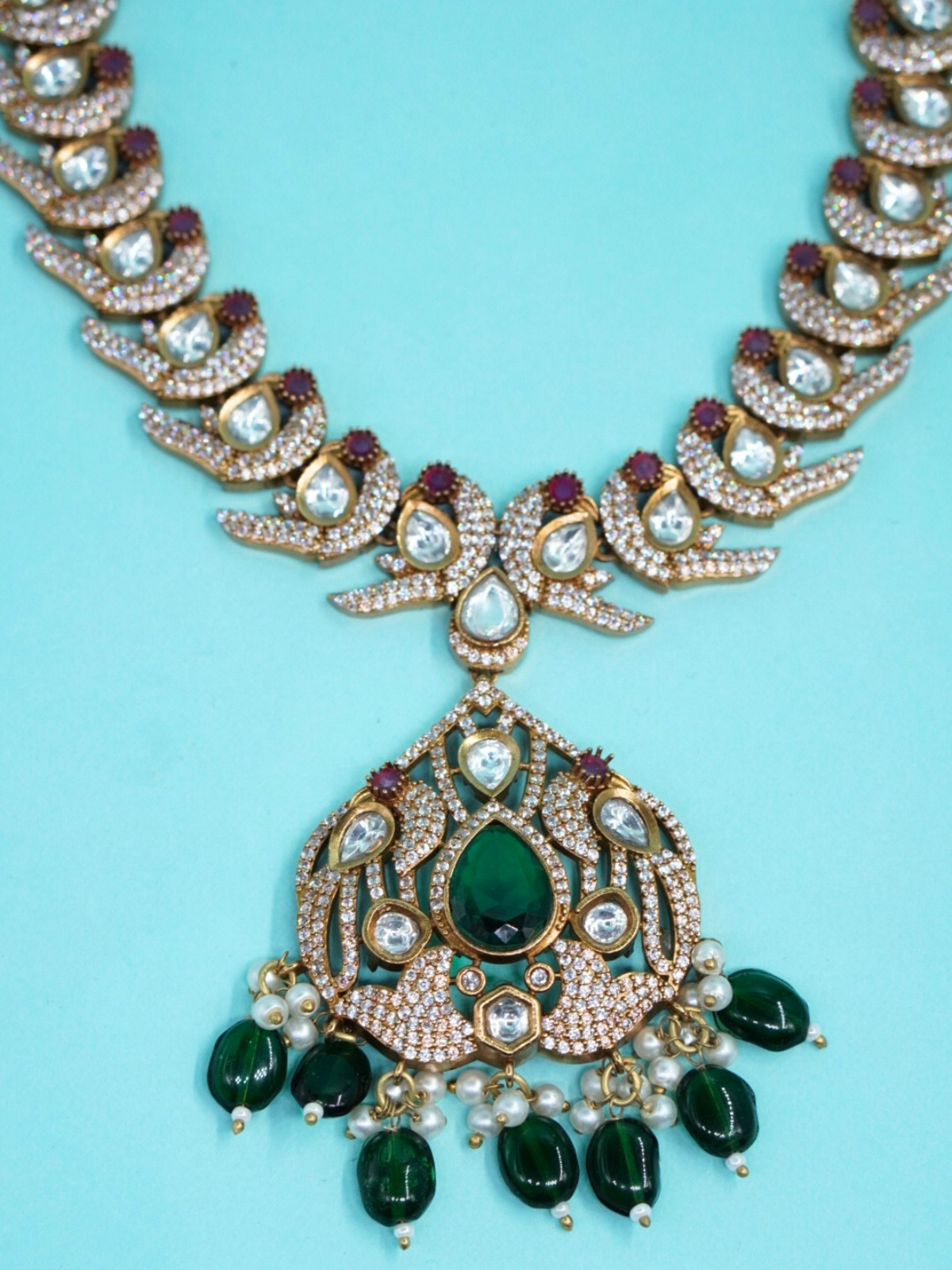 Moissanite stone necklace set with green drop beads on blue background