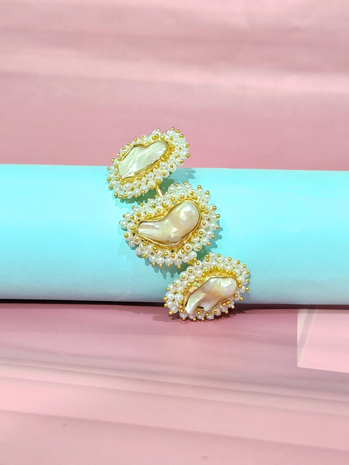 Mother of Pearl bracelet in brass with pearl beading on  blue and pink background