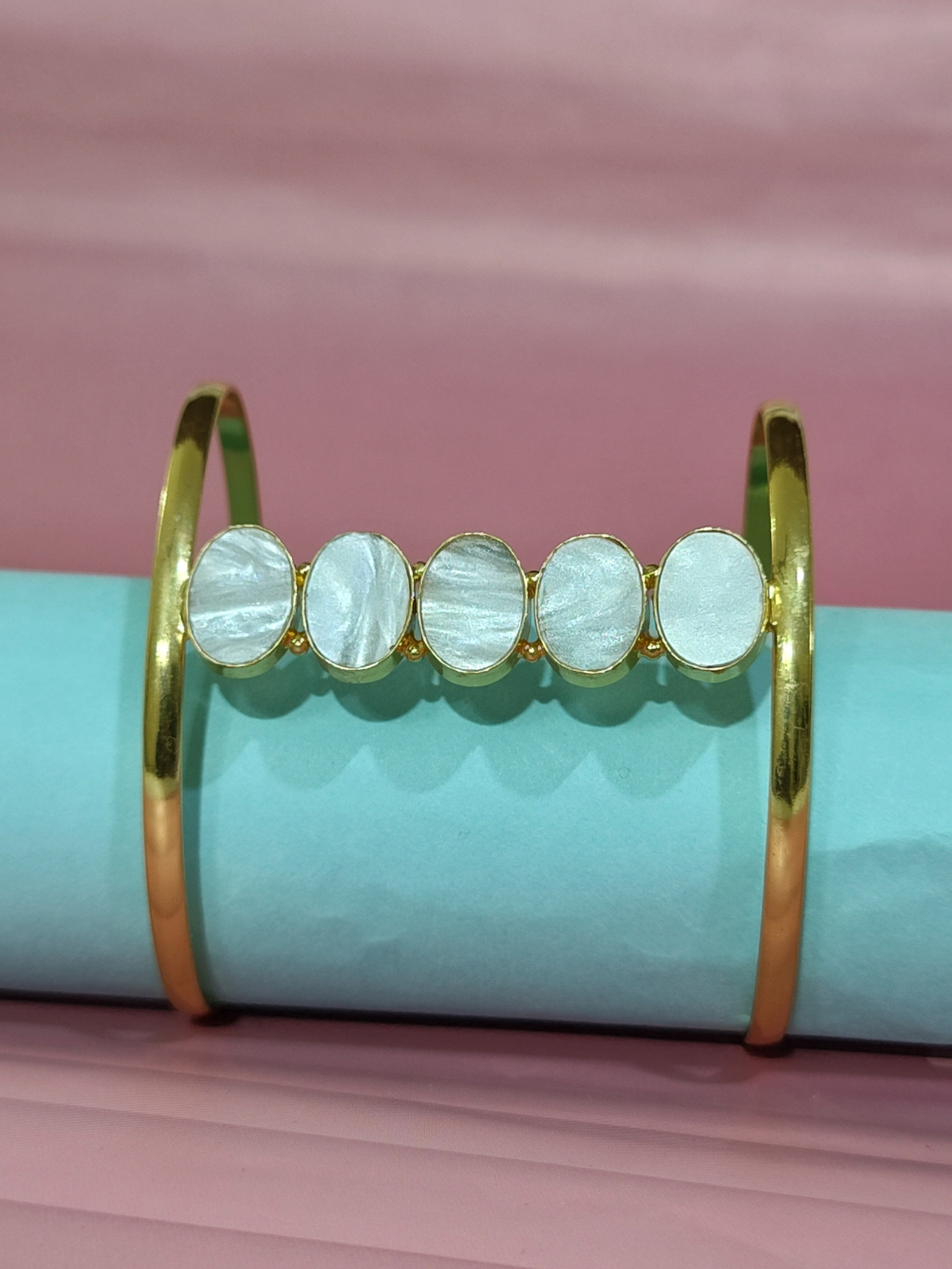 Mother of Pearl cuff bracelet in brass on pink and blue background
