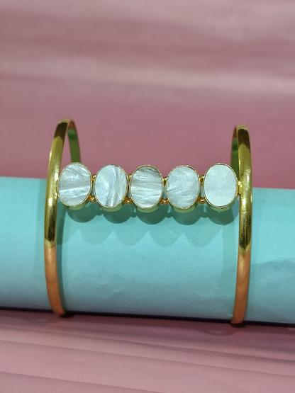 Mother of Pearl cuff bracelet in brass on pink and blue background