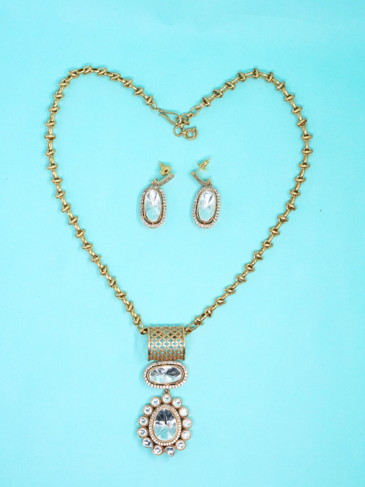 Royal Moissanite pendant necklace set with matching oval earrings on blue background