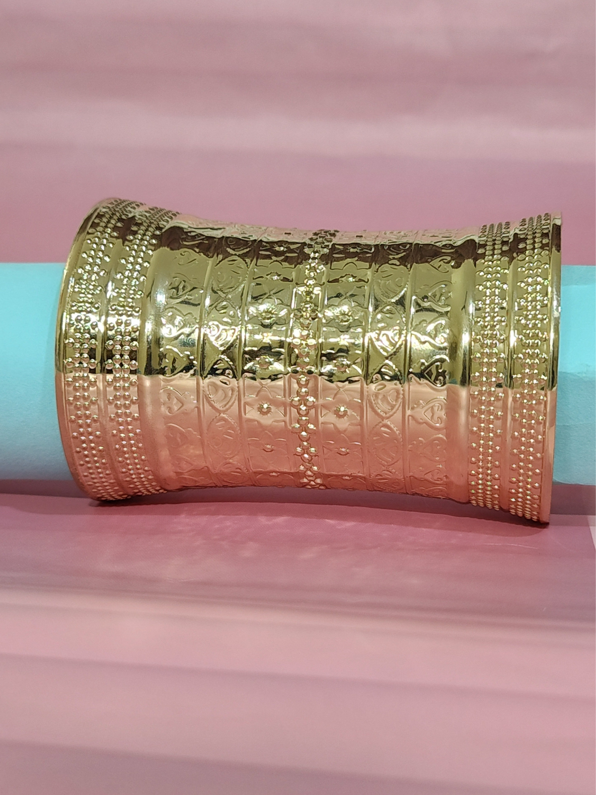 Royal anti-tarnish gold finish textured wide stainless steel bracelet  on a blue background 