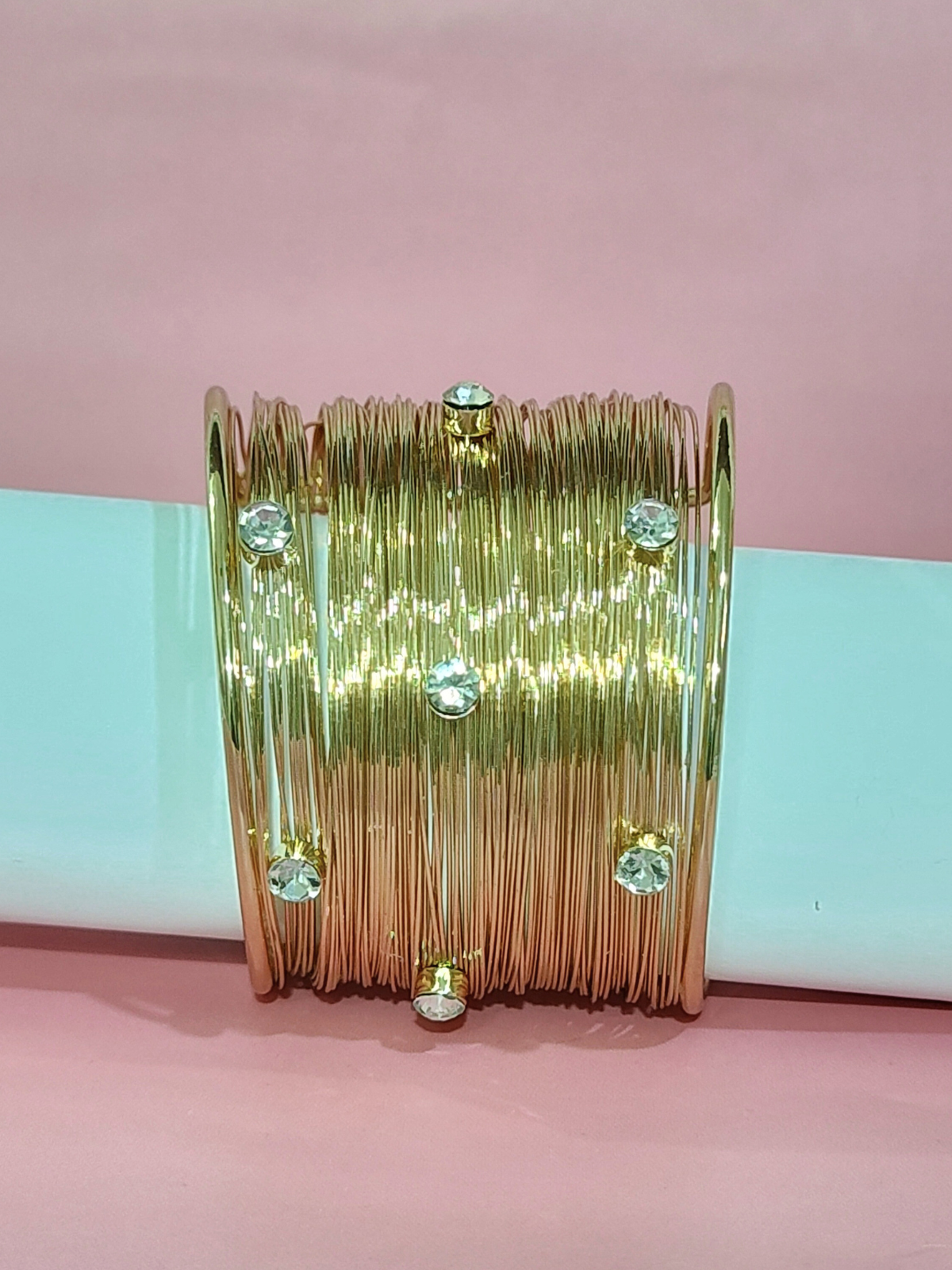 Royal anti-tarnish gold finish wide bracelet with stones on blue background 