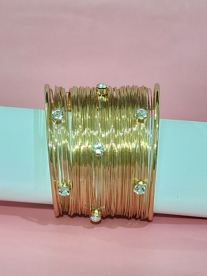 Royal anti-tarnish gold finish wide bracelet with stones on blue background 