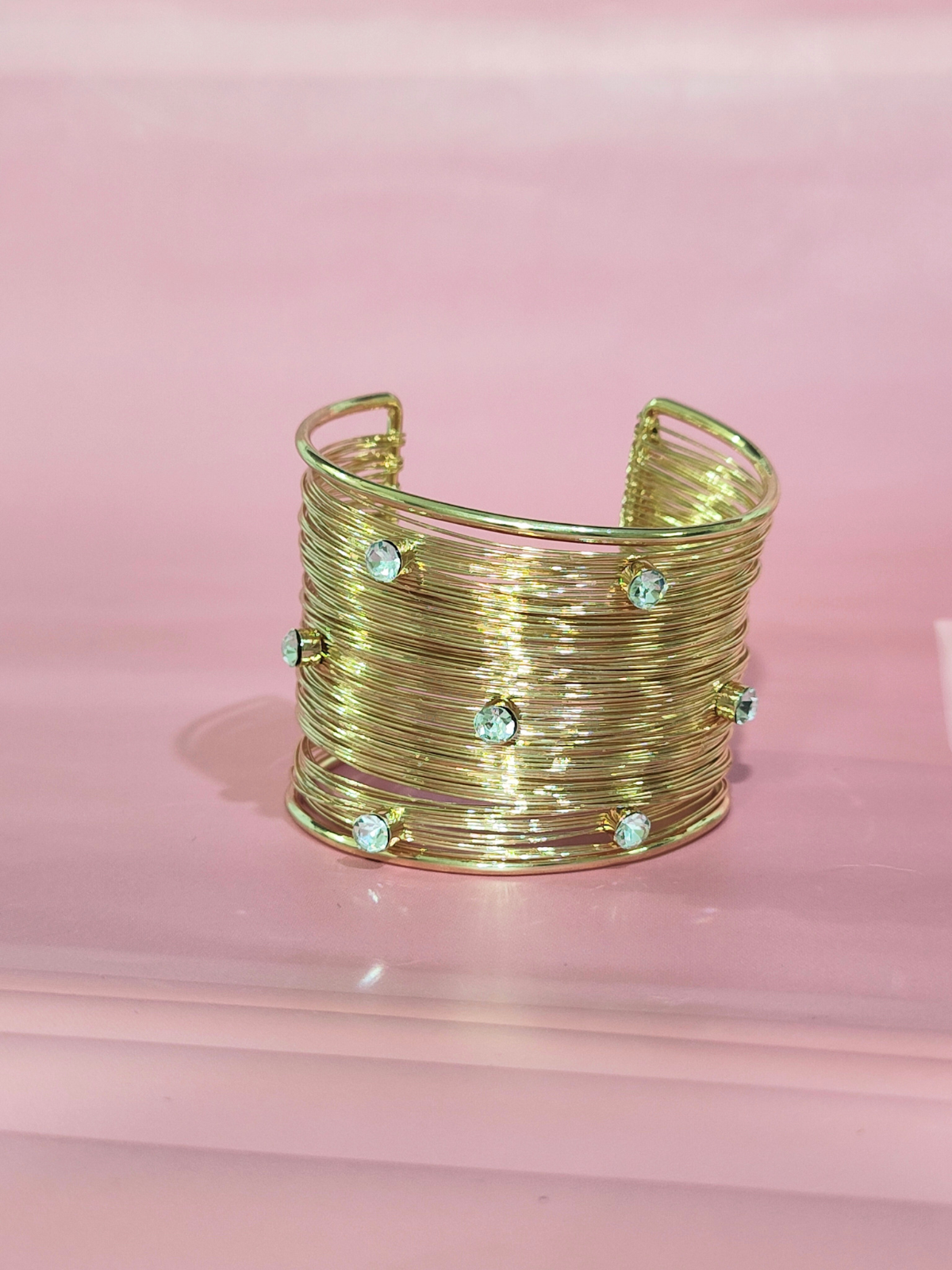 Royal anti-tarnish gold finish wide bracelet with stones on pink background