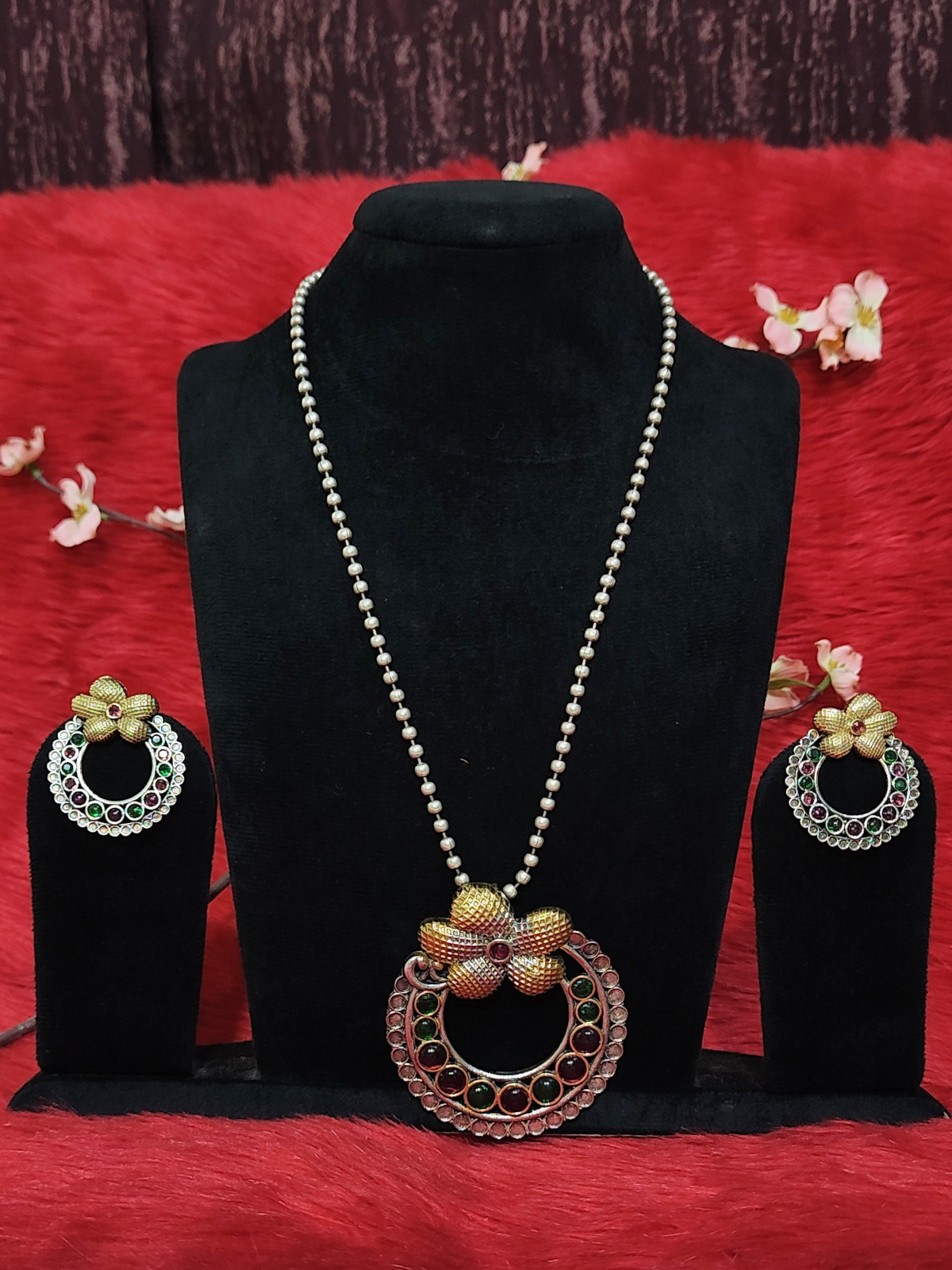 Silver replica floral pendant necklace set with white bead chain, ruby and green stones, and matching earrings