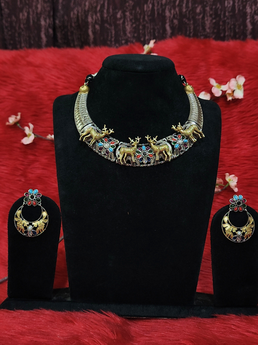 Silver replica dual tone necklace set with antique gold deer motifs, colorful enamel work, and matching earrings on black display stand