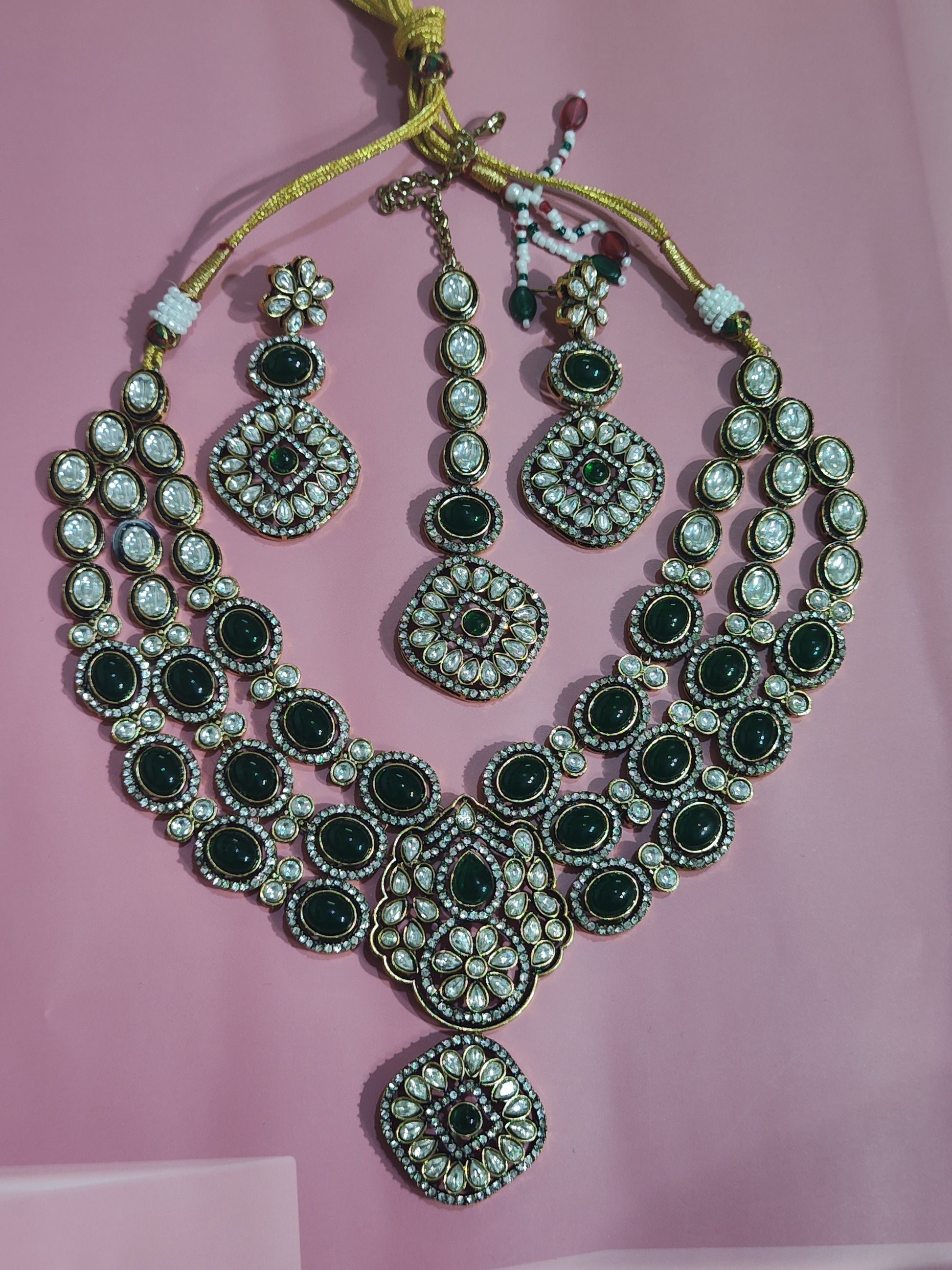 Triple-layer green kundan bridal necklace set with pendant, earrings, and maang tika 