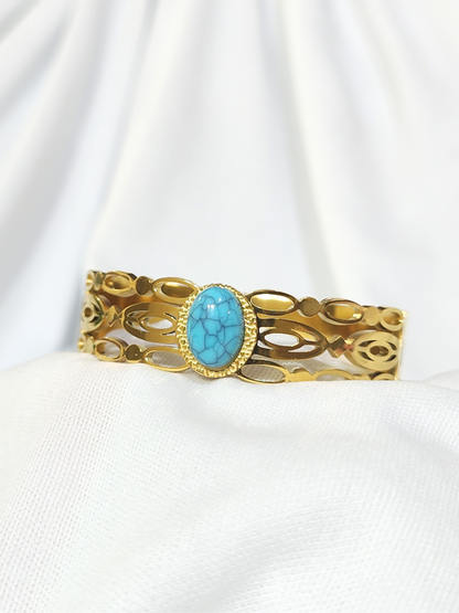 Turquoise stone wide gold finish bracelet with open cut design close view