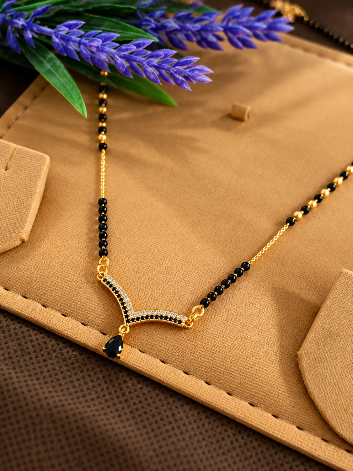 Black bead mangalsutra necklace with V-shaped stone pendant and black teardrop