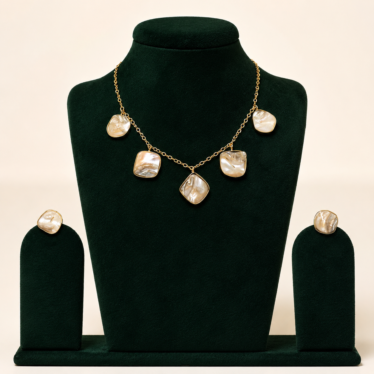 Mother-of-pearl brass necklace set displayed on green velvet jewellery bust