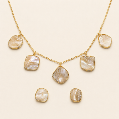 Gold-tone brass mother-of-pearl five-drop necklace and earrings flat lay