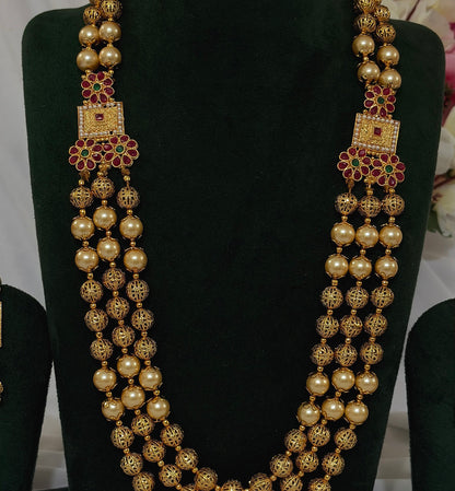 Close-up of copper-finish Matar Mala necklace with filigree beads and red and green floral details