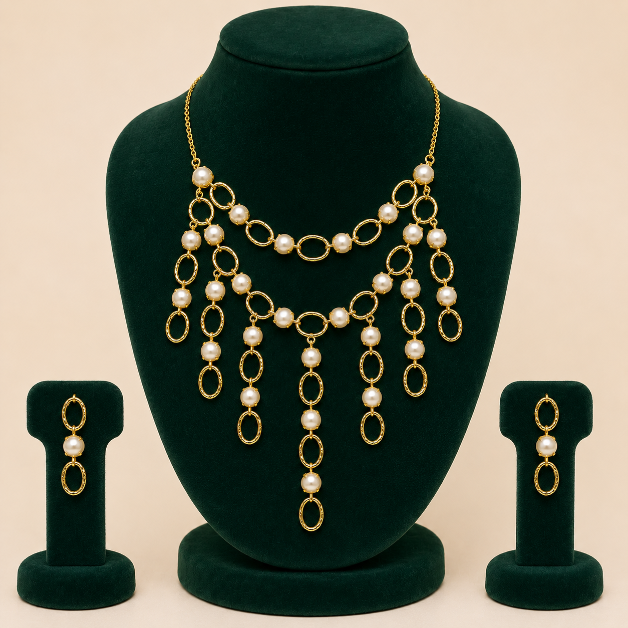 Brass pearl-style cascading necklace and earrings displayed on green jewellery bust