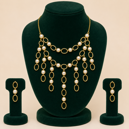 Brass pearl-style cascading necklace and earrings displayed on green jewellery bust
