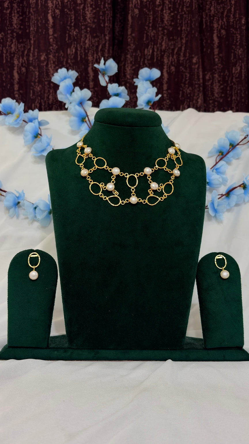 Handmade brass organic-link statement necklace set displayed on green jewellery bust