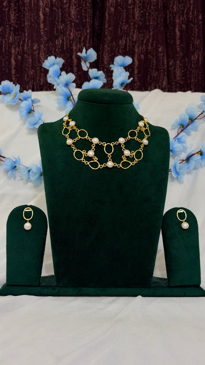 Handmade brass organic-link statement necklace set displayed on green jewellery bust