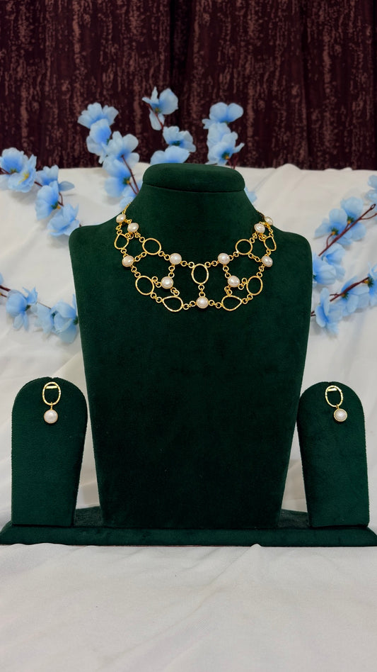 Handmade brass organic-link statement necklace set displayed on green jewellery bust