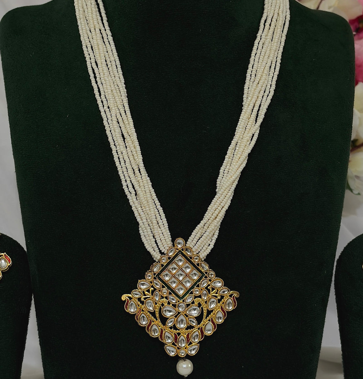 Close-up of Kundan-style pendant with clear decorative stones and pearl-like strands