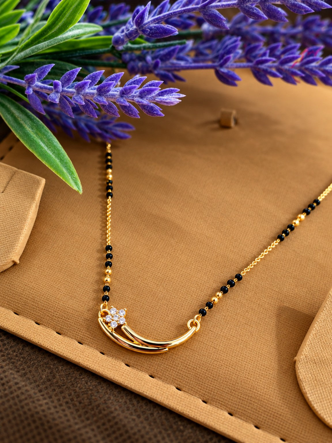 Micro gold-plated black bead mangalsutra with curved pendant and floral stone detail
