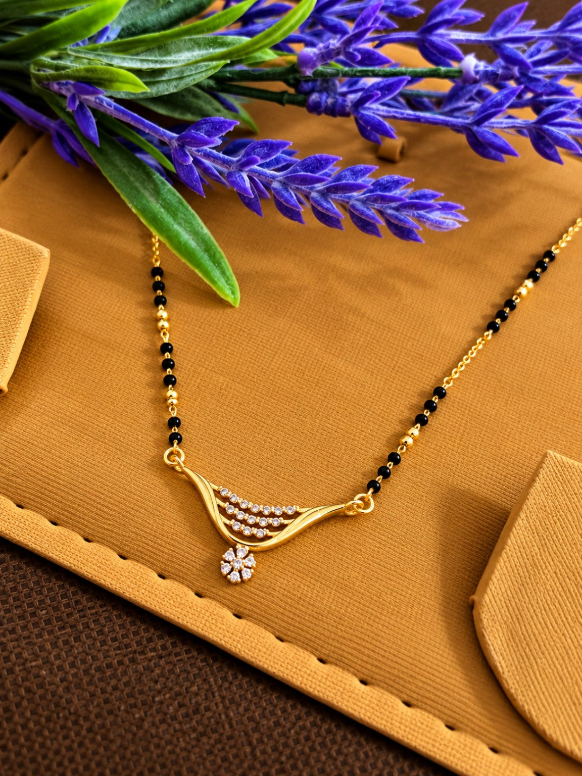 Micro gold-plated black bead mangalsutra with layered curved stone pendant and floral drop