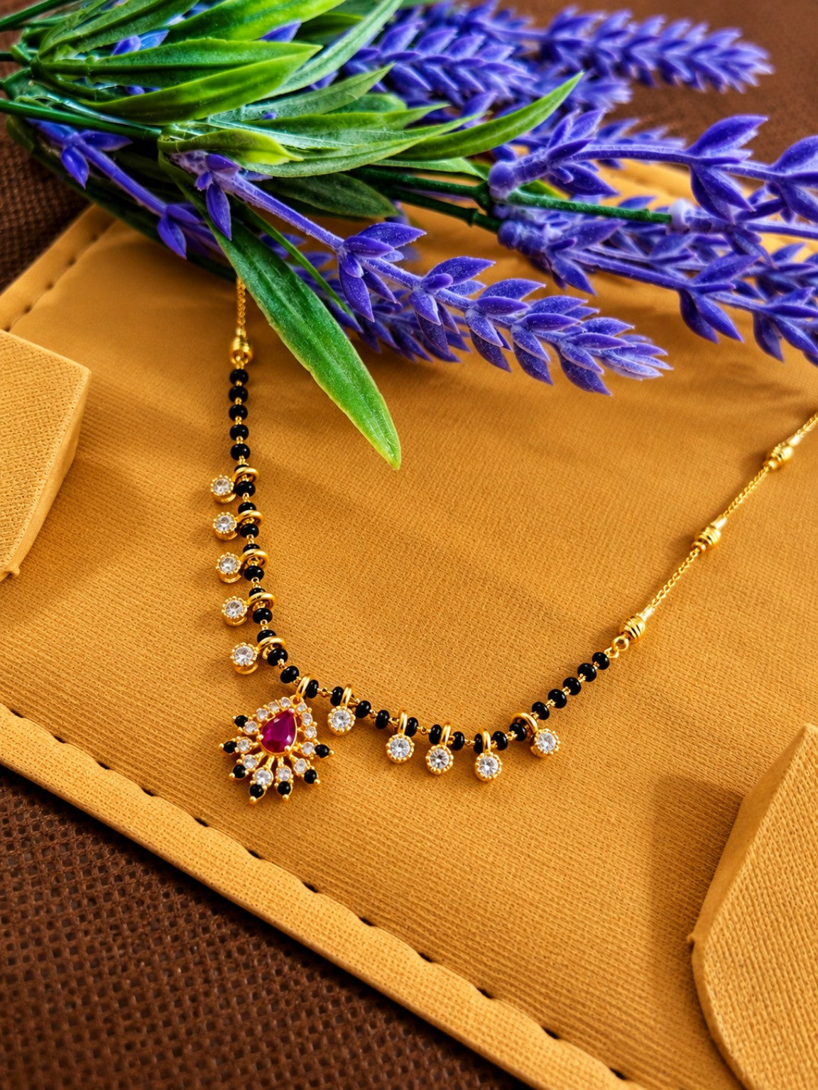 Micro gold-plated black bead mangalsutra with red teardrop floral pendant and clear stone charms