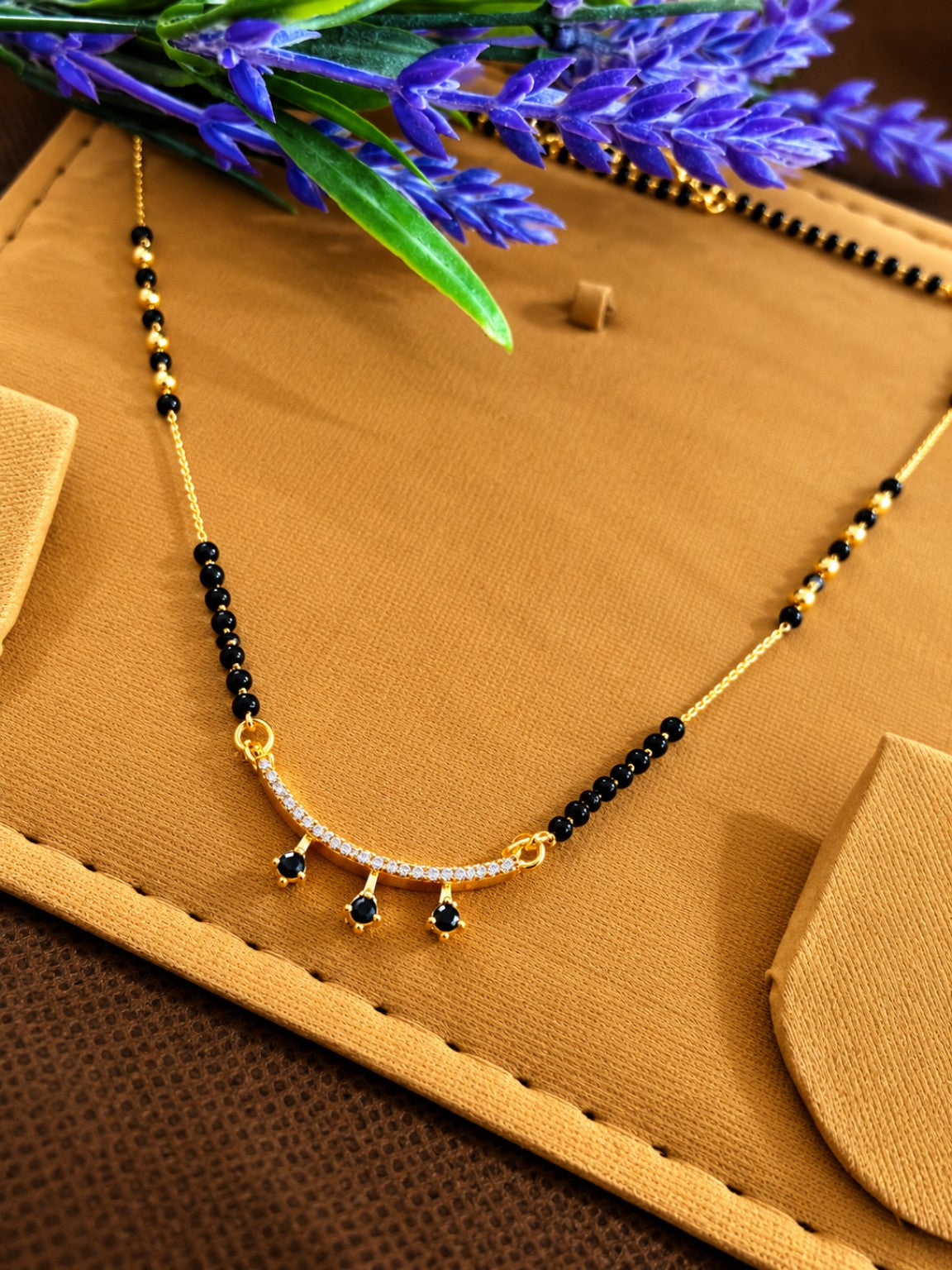 Micro gold-plated black bead mangalsutra with curved stone bar and three black teardrop drops