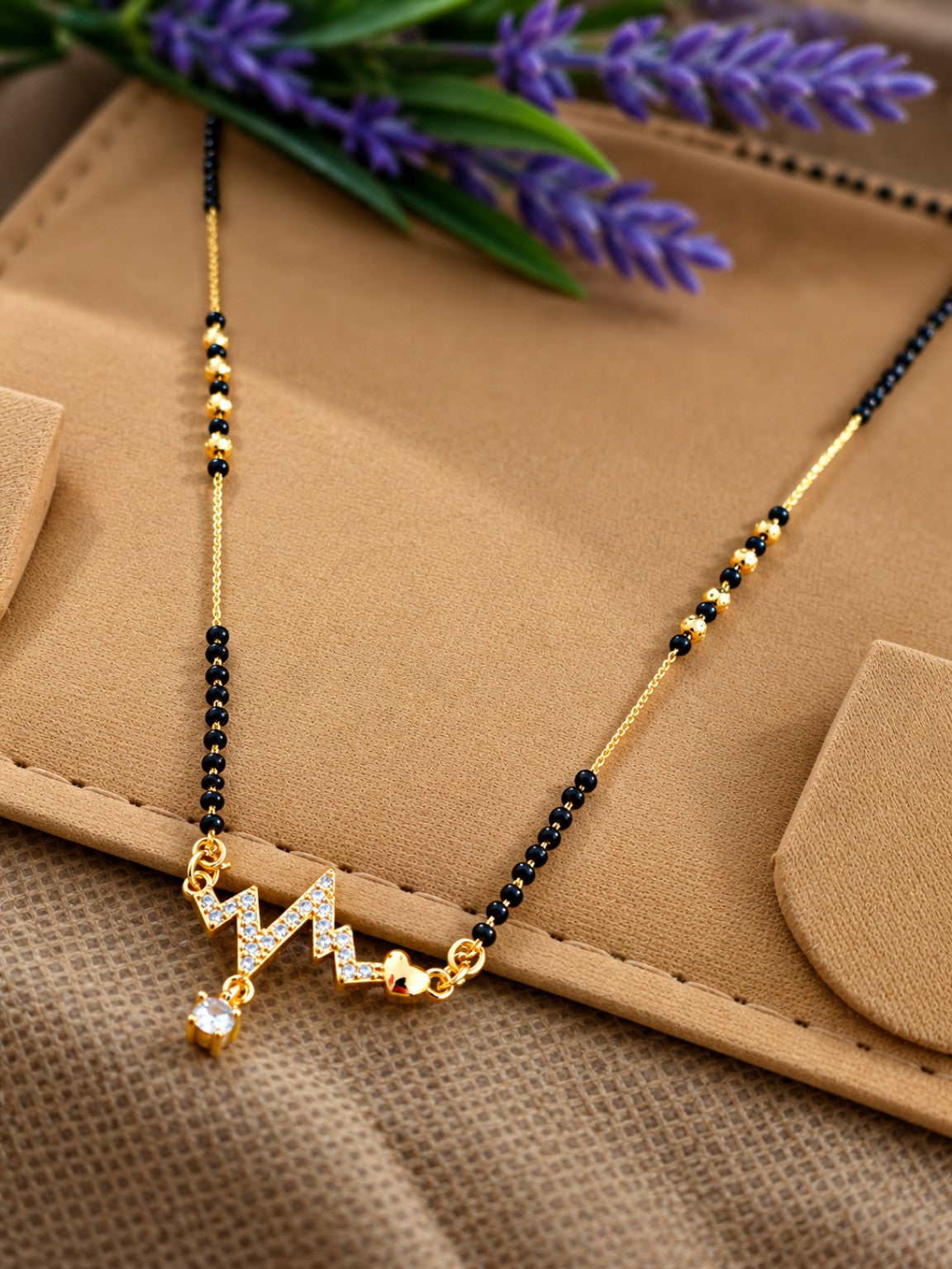 Micro gold-plated black bead mangalsutra with zigzag stone pendant, clear stone drop and heart charm