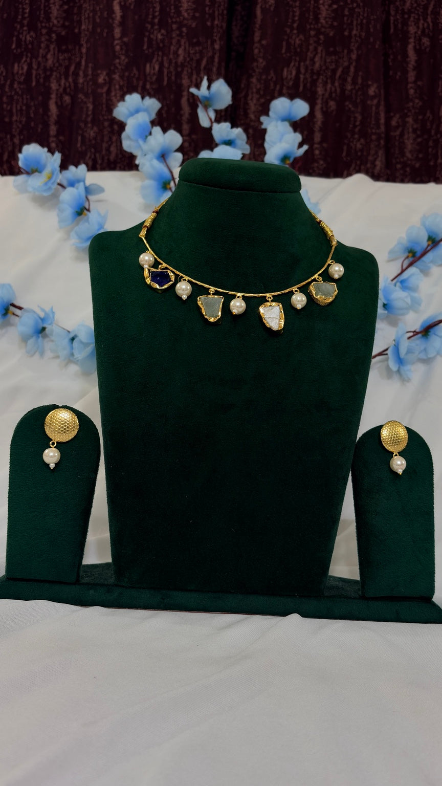 Natural semi-precious stone necklace set with matching earrings on green display