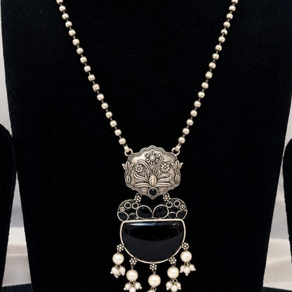 Close-up of oxidised silver replica black stone pendant with pearl-style drops