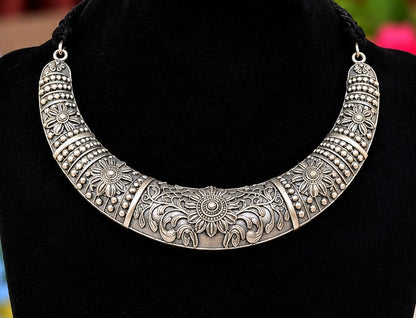 Close-up of oxidised silver replica floral collar necklace with engraved detailing