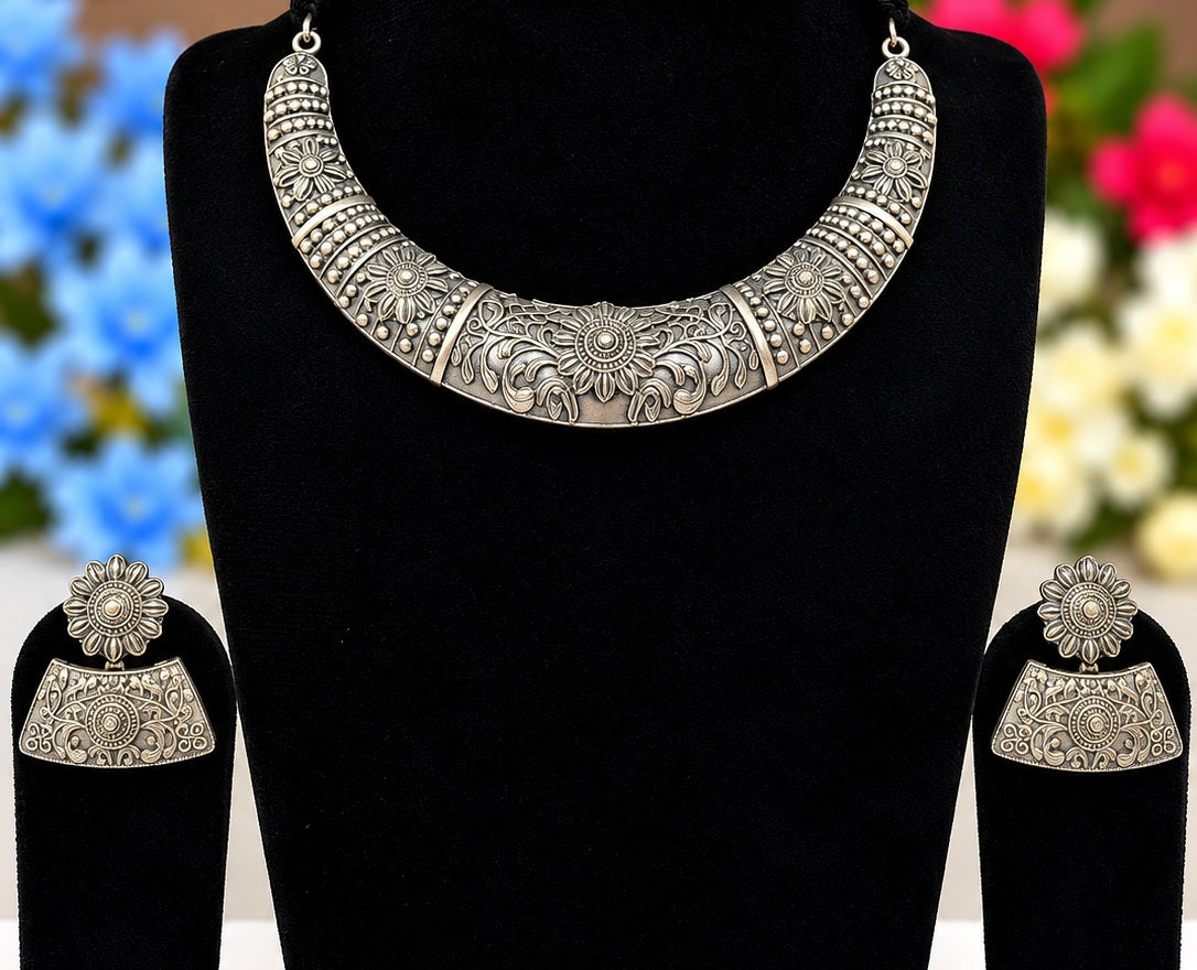 Detail view of oxidised silver replica floral necklace and matching statement earrings