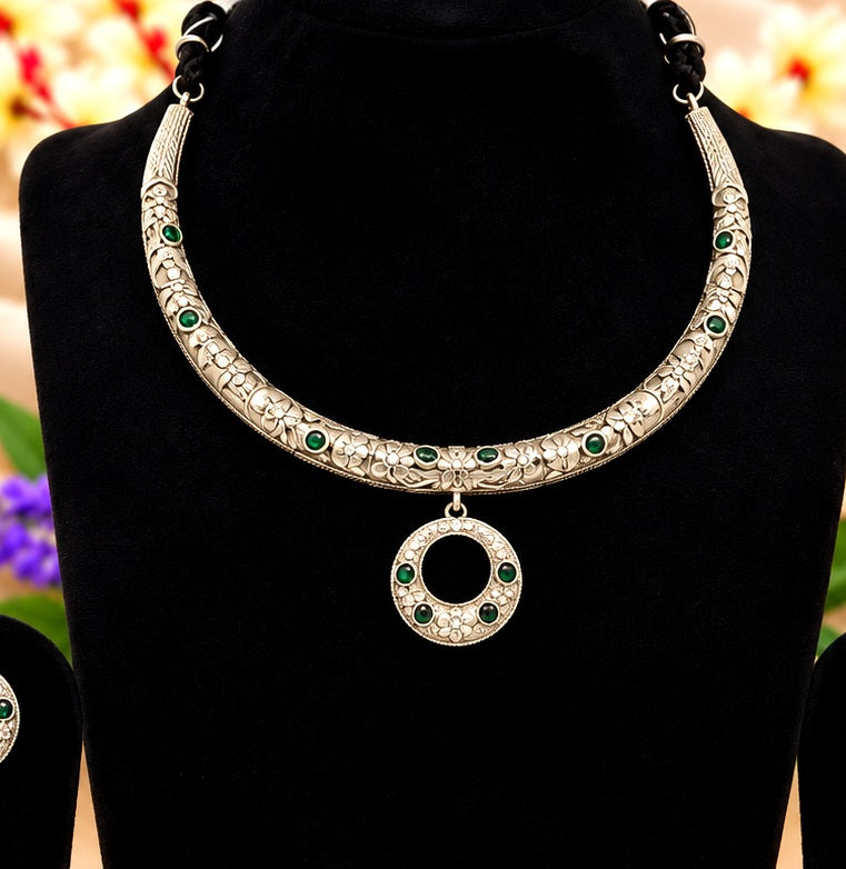 Close-up of oxidised silver replica floral collar necklace with green stones